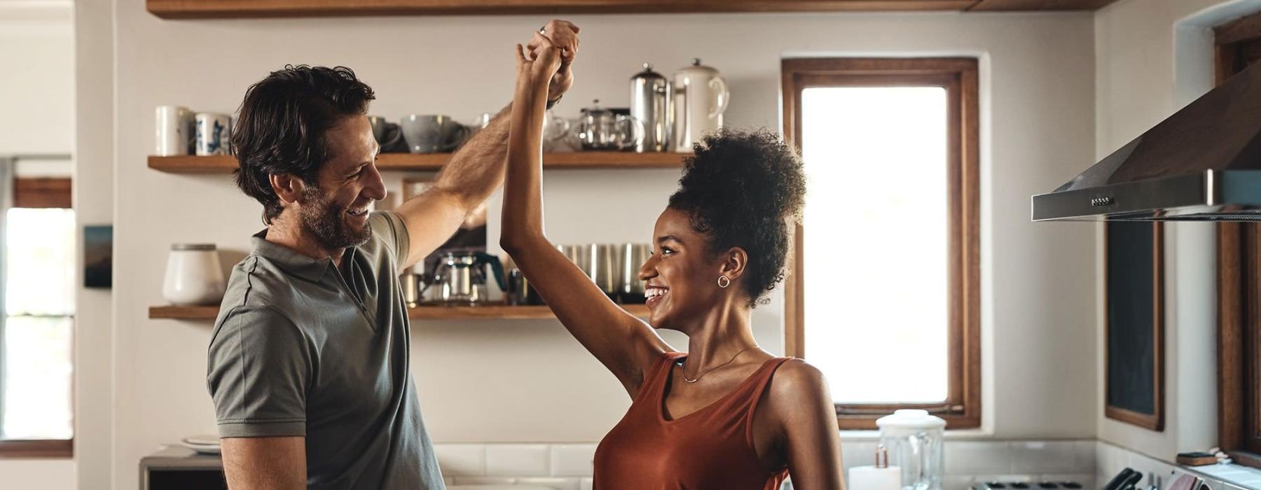 a man and a woman dance in well lit kitchen